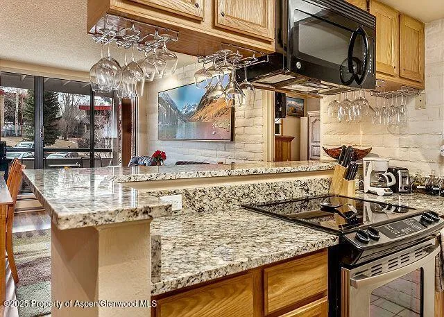 a kitchen with stainless steel appliances granite countertop a sink stove and microwave