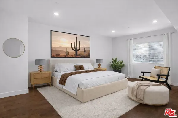 a large spacious bathroom with a granite countertop sink a toilet a mirror and shower