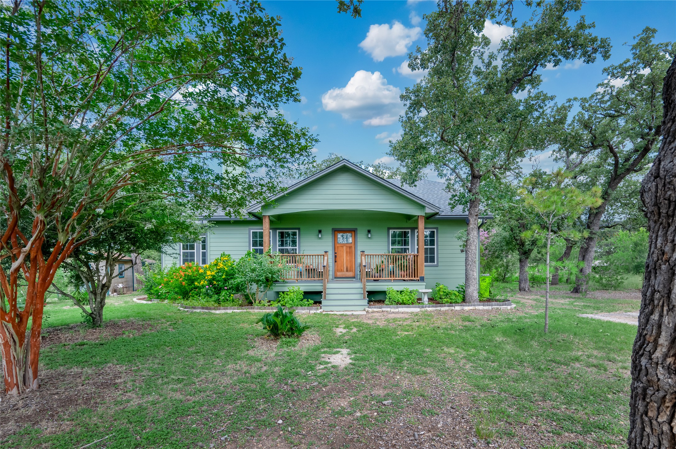 270 Dry Creek Road Manor, TX 78653 - Photo 2 of 40 A welcoming front porch, shaded by mature trees, invites quiet moments on this charming residence.