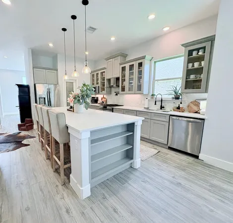 a large kitchen with kitchen island a sink a center island stainless steel appliances and a window