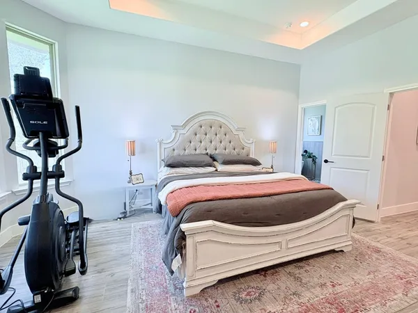 a spacious bedroom with a bed and a flat screen tv