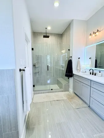 a bathroom with a double vanity sink toilet and shower