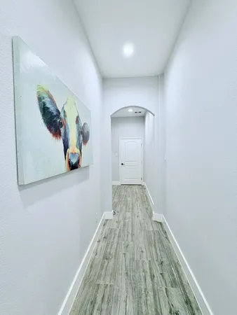 a view of a hallway with wooden floor and closet