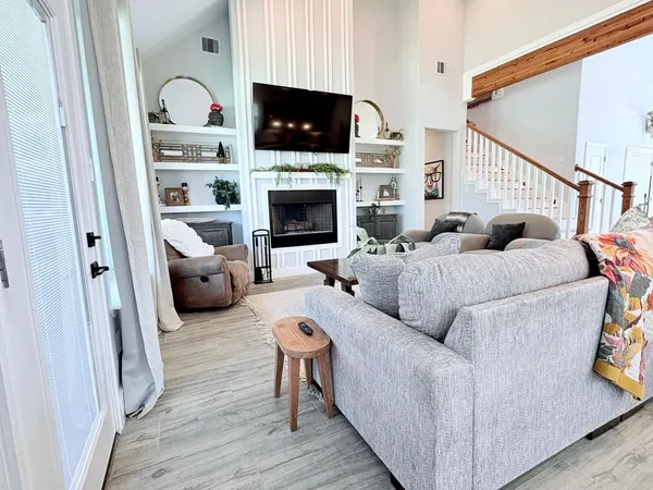 a living room with furniture a flat screen tv and a fireplace