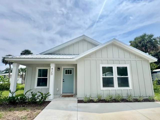 a front view of a house with plants