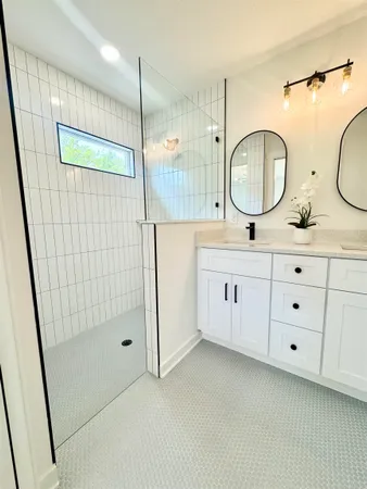 a bathroom with a double vanity sink mirror and shower