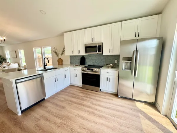 a kitchen with white cabinets stainless steel appliances and a counter space