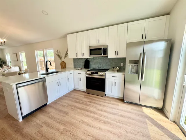a kitchen with white cabinets stainless steel appliances and a counter space