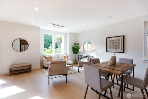 a living room with furniture a large window and a potted plant