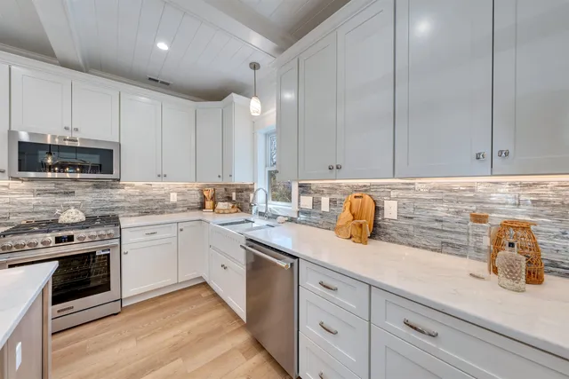 a kitchen with granite countertop white cabinets and white appliances