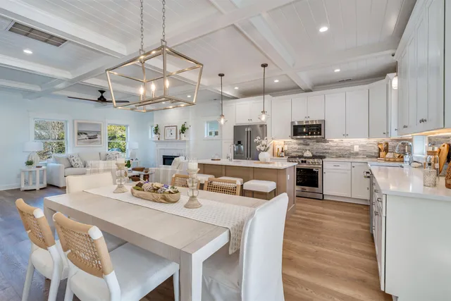 a kitchen with stainless steel appliances kitchen island granite countertop a table chairs and a refrigerator