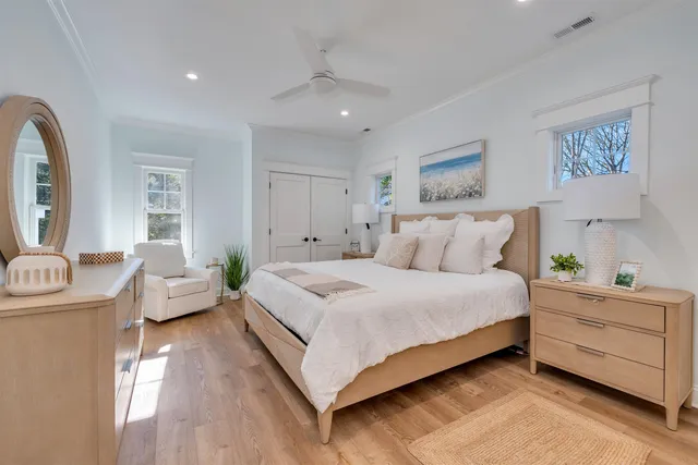 a spacious bedroom with a bed and wooden floor
