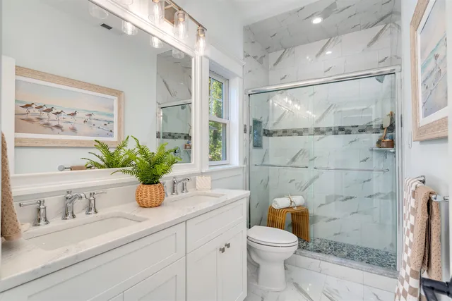 a bathroom with a granite countertop sink a toilet and shower