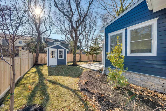 a view of a house with a yard and large tree