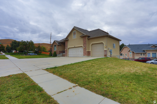 426 Deer Hollow Road Tooele, UT 84074 - Photo 30 of 37 Traditional home featuring stucco siding, concrete driveway, a front yard, and a garage