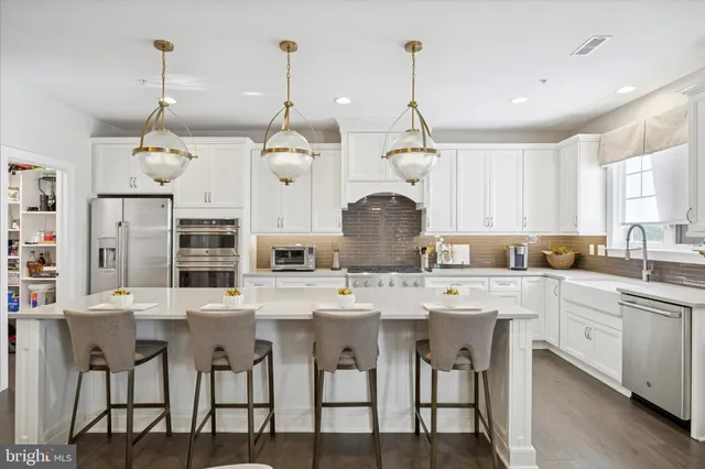 a kitchen with stainless steel appliances granite countertop white cabinets and a stove