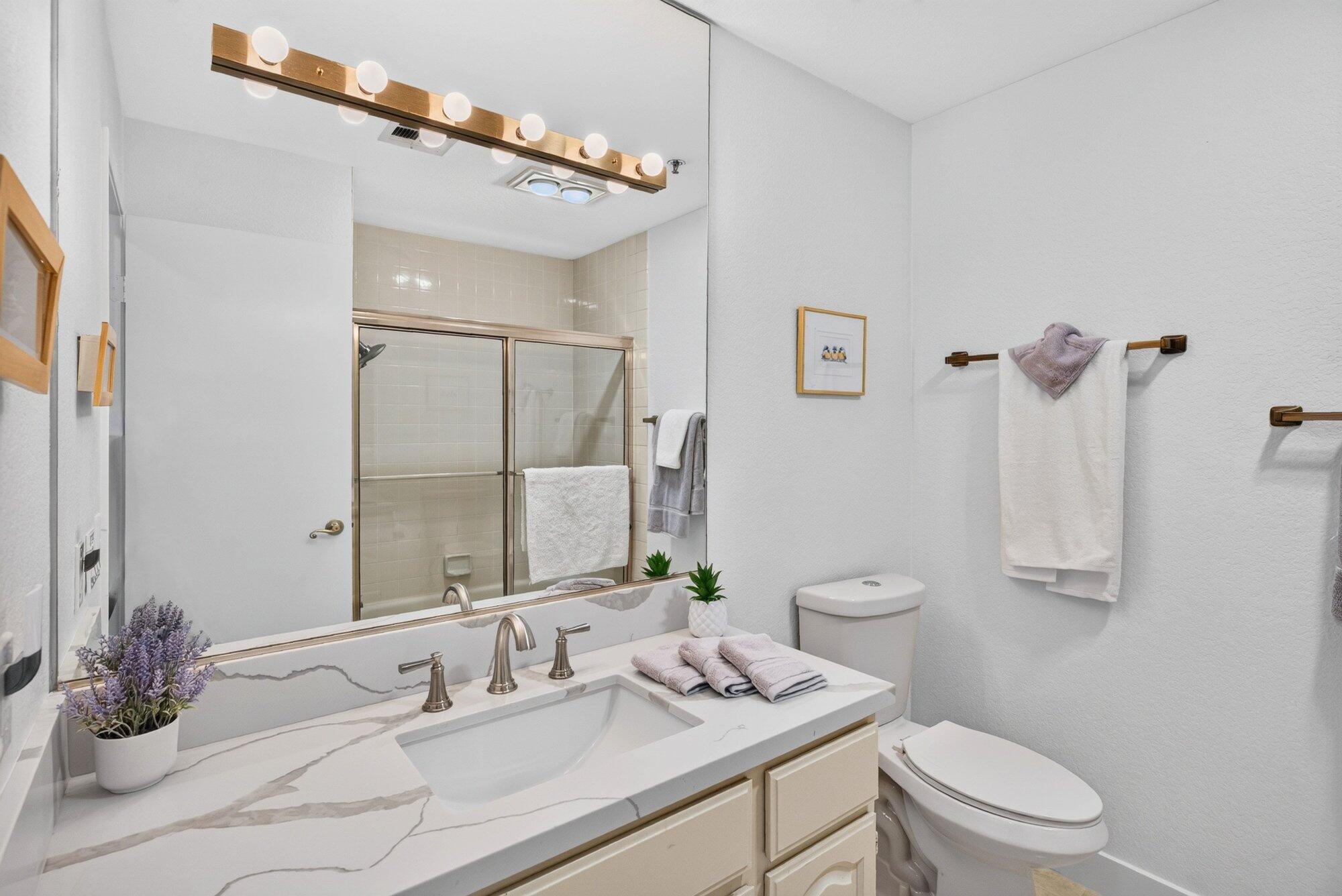 500 East Amado Road, Unit 313 Palm Springs, CA 92262 - Photo 17 of 32 a bathroom with a granite countertop sink a toilet and a mirror