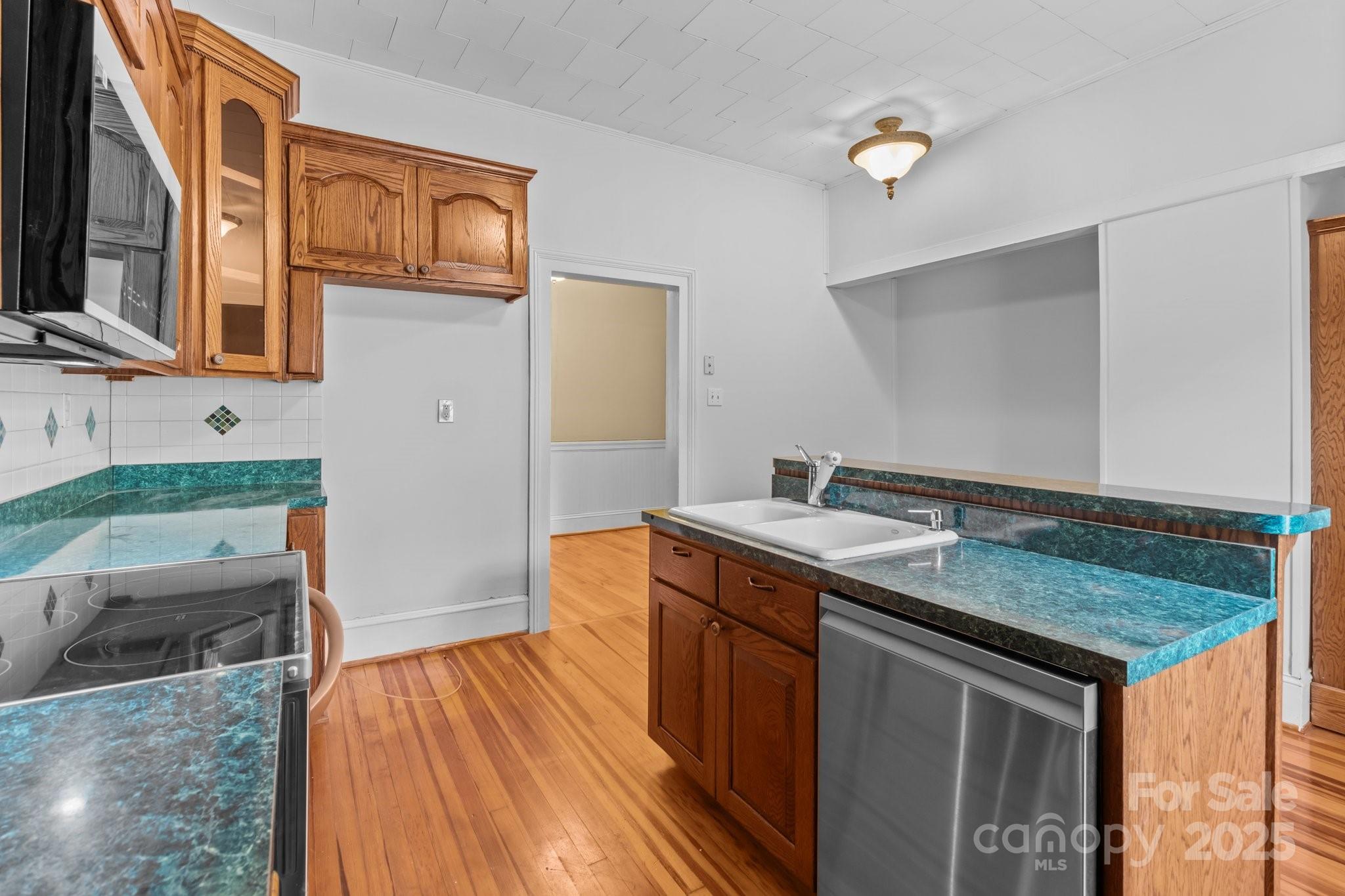 405 7th Street Spencer, NC 28159 - Photo 14 of 39 a kitchen that has a sink and a wooden floor