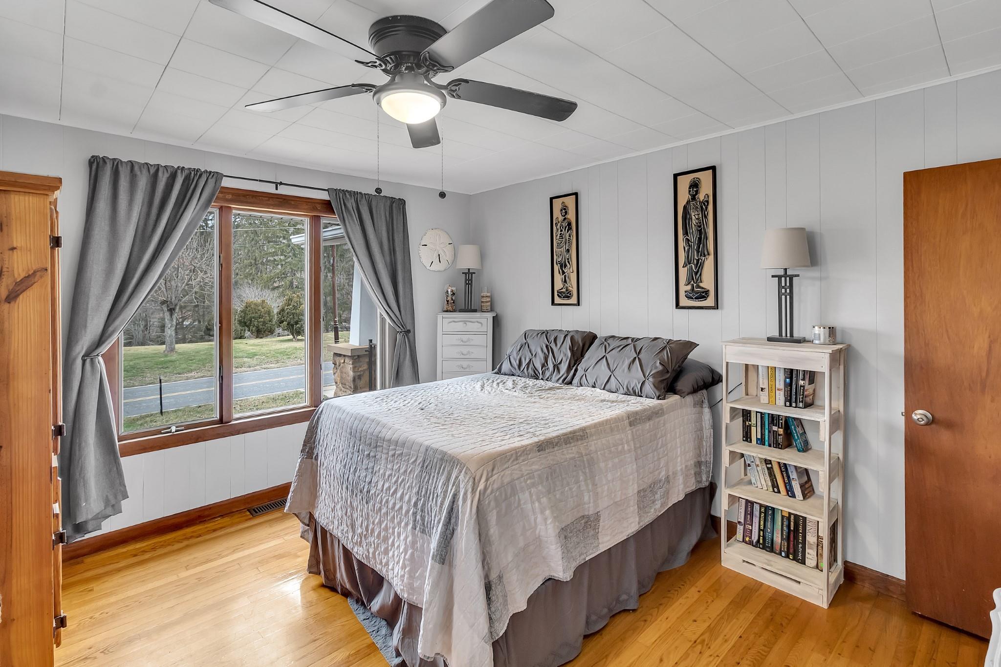 670 Thompson Cove Road Clyde, NC 28721 - Photo 23 of 45 a bedroom with a large bed and a chandelier fan