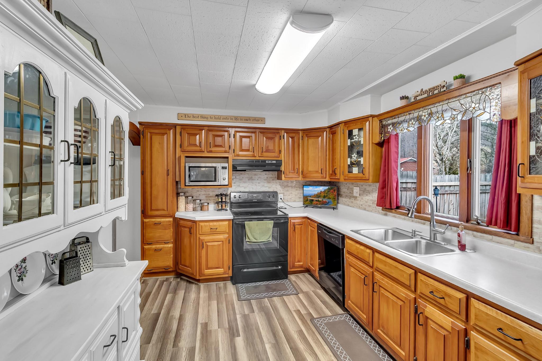 670 Thompson Cove Road Clyde, NC 28721 - Photo 3 of 45 a kitchen with stainless steel appliances granite countertop a sink and wooden cabinets