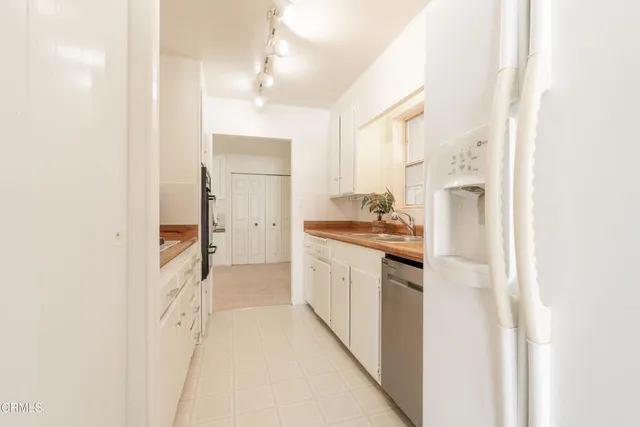 a room with appliances a sink and a cabinets
