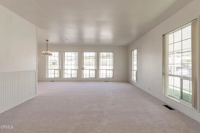 an empty room with a ceiling fan and window
