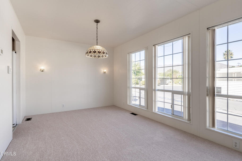 1202 Loma Drive, Unit 42 Ojai, CA 93023 - Photo 10 of 28 an empty room with windows and chandelier
