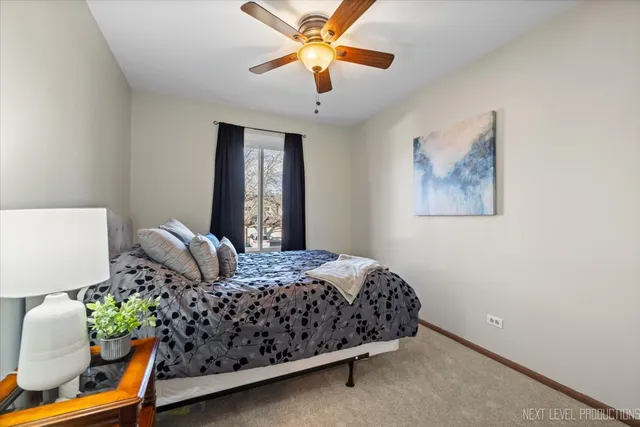 a bedroom with a bed and a chandelier fan