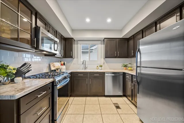 a kitchen with stainless steel appliances granite countertop a sink stove and cabinets