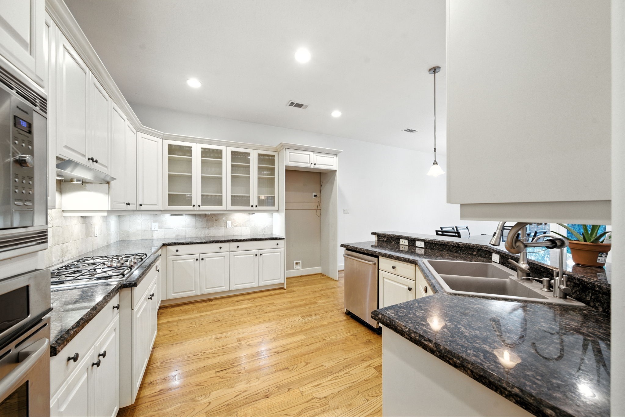 2714 Stuart Manor Houston, TX 77082 - Photo 20 of 49 From this angle, the kitchen reveals its excellent workspace with a large sink, stainless Bosch dishwasher, and wraparound counters. Overhead lighting and arched openings add charm and warmth to the design.