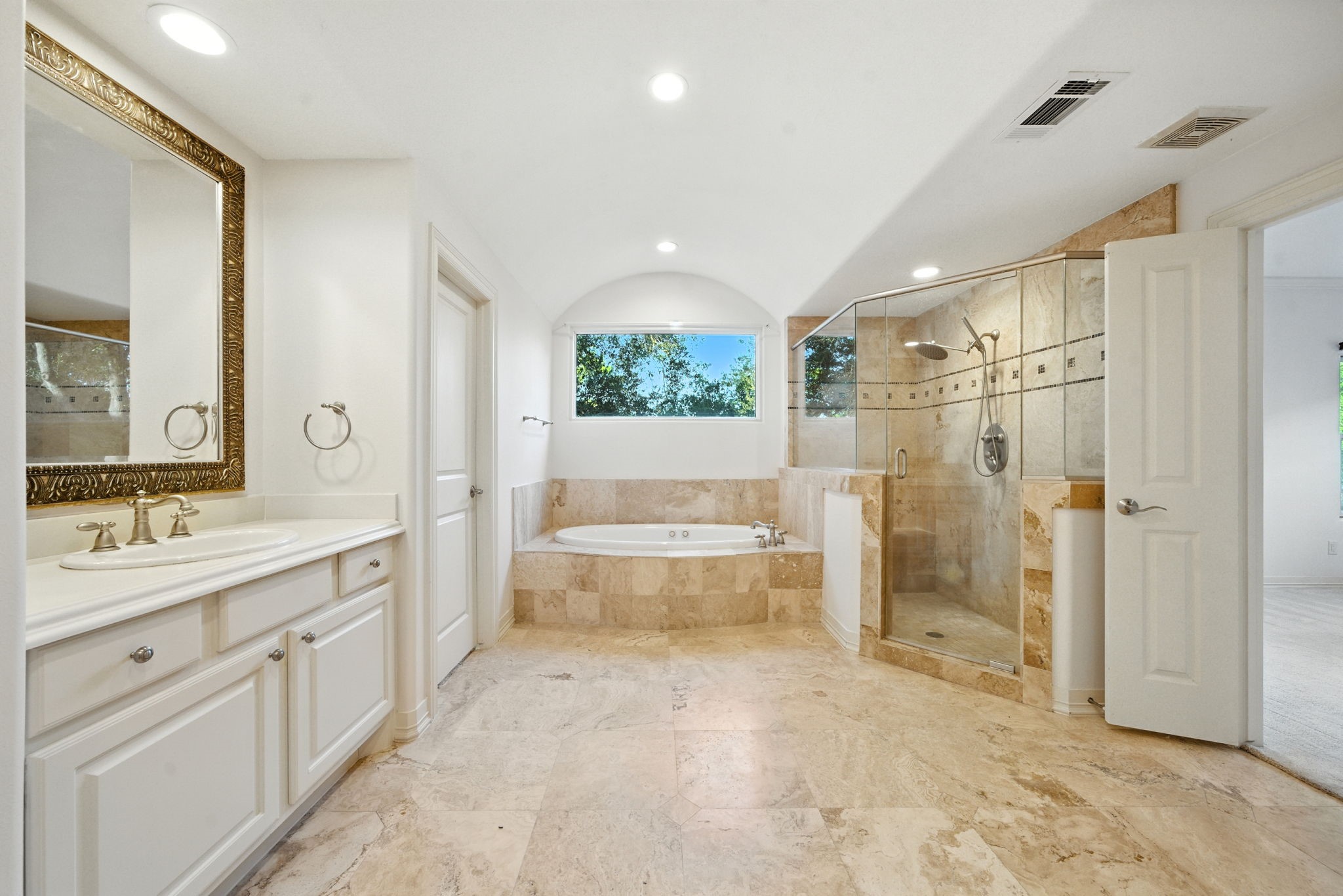 2714 Stuart Manor Houston, TX 77082 - Photo 28 of 49 Unwind in your own spa-inspired retreat featuring a deep whirlpool tub, walk-in shower with stone tile accents, and abundant natural light that creates a serene atmosphere.