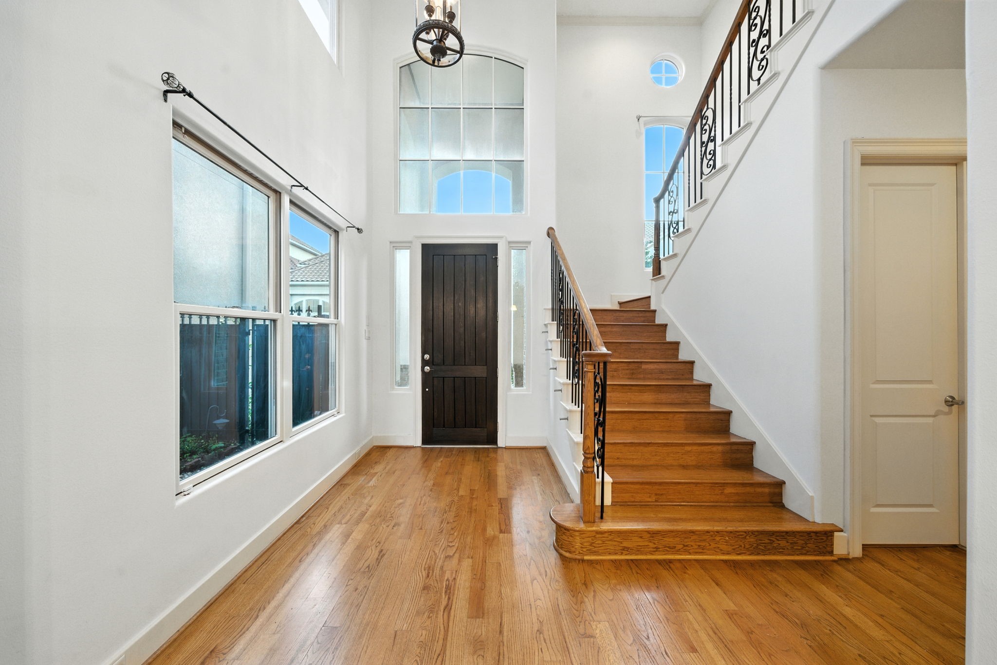 2714 Stuart Manor Houston, TX 77082 - Photo 4 of 49 The grand entryway welcomes you with soaring ceilings, abundant natural light, and a striking staircase accented by wrought iron detail—setting the tone for the home’s impressive interior.
