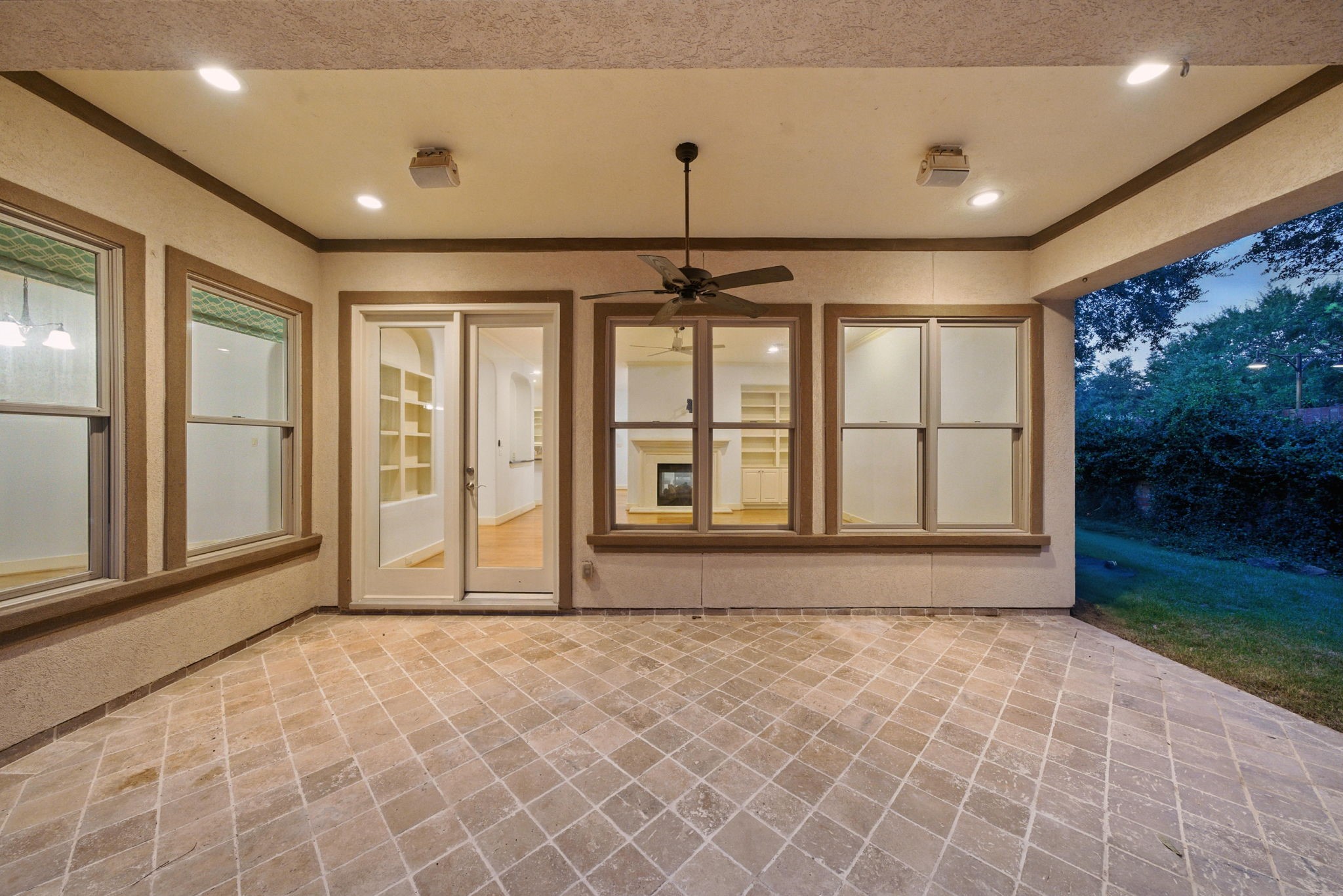 2714 Stuart Manor Houston, TX 77082 - Photo 42 of 49 Step outside to a backyard designed for both relaxation and entertaining. The covered patio features elegant tilework, recessed lighting, and a ceiling fan for year-round comfort, creating the perfect spot for dining al fresco or unwinding at the end of the day.