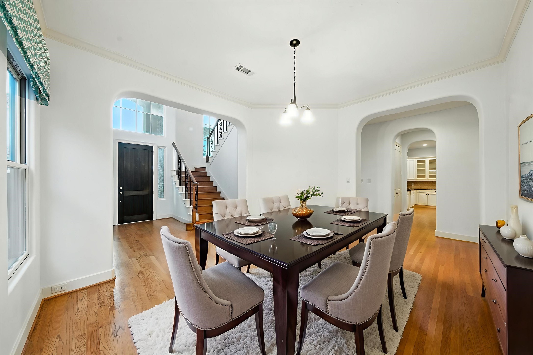 2714 Stuart Manor Houston, TX 77082 - Photo 5 of 49 Image is Virtually Staged - The formal dining room offers a refined setting with tall windows, hardwood flooring, and graceful archways that connect beautifully to the main living areas—perfect for hosting dinners and celebrations.
