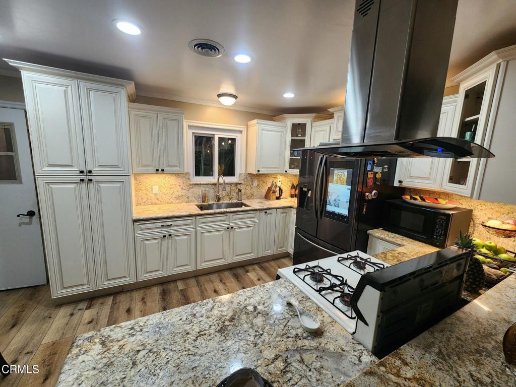 1440 Morris Street Oxnard, CA 93030 - Photo 3 of 7 a kitchen with granite countertop a refrigerator stove and sink