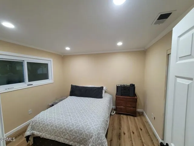 a bedroom with a bed and wooden floor