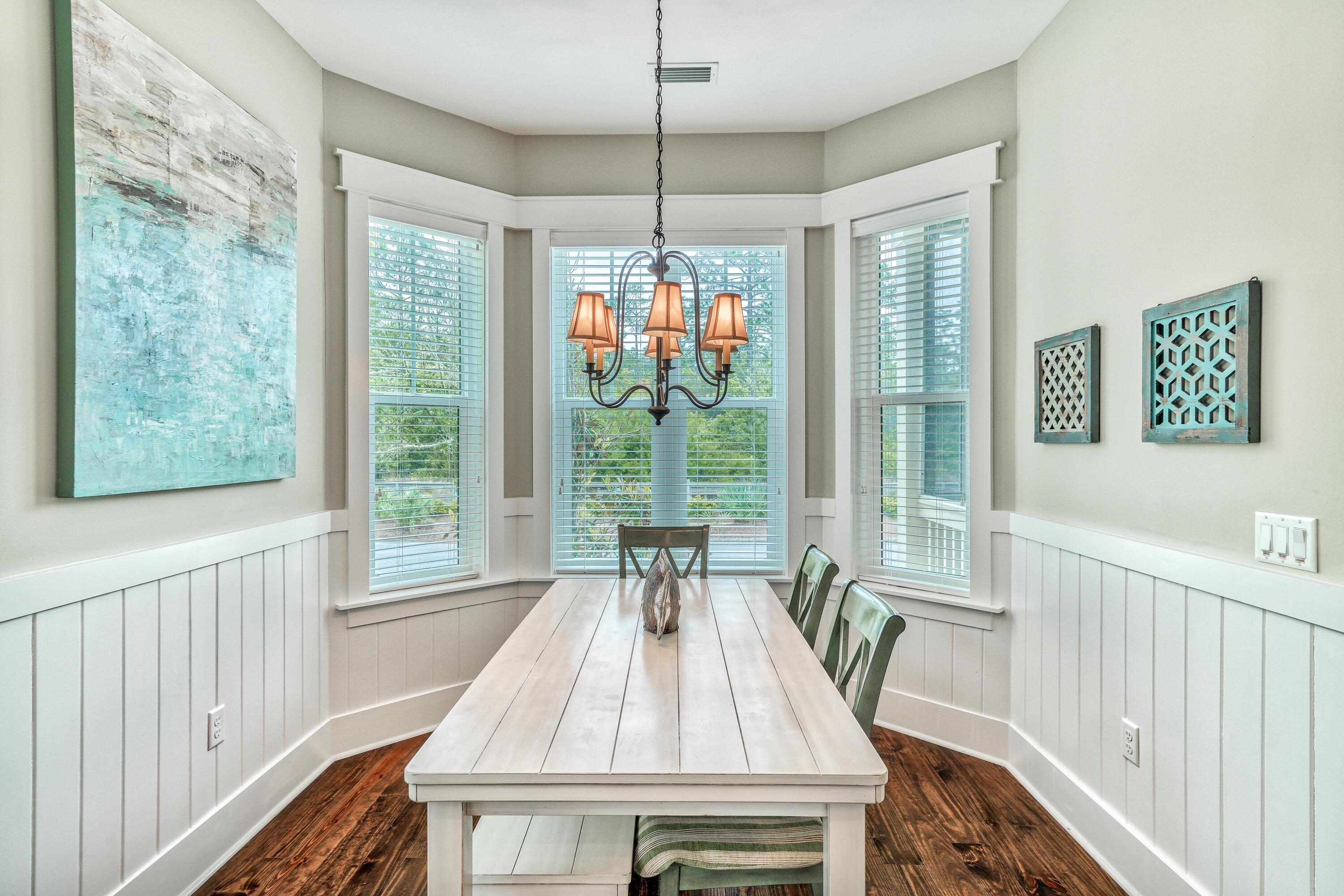 985 Sandgrass Boulevard Santa Rosa Beach, FL 32459 - Photo 12 of 65 a view of a dining room with furniture wooden floor and windows