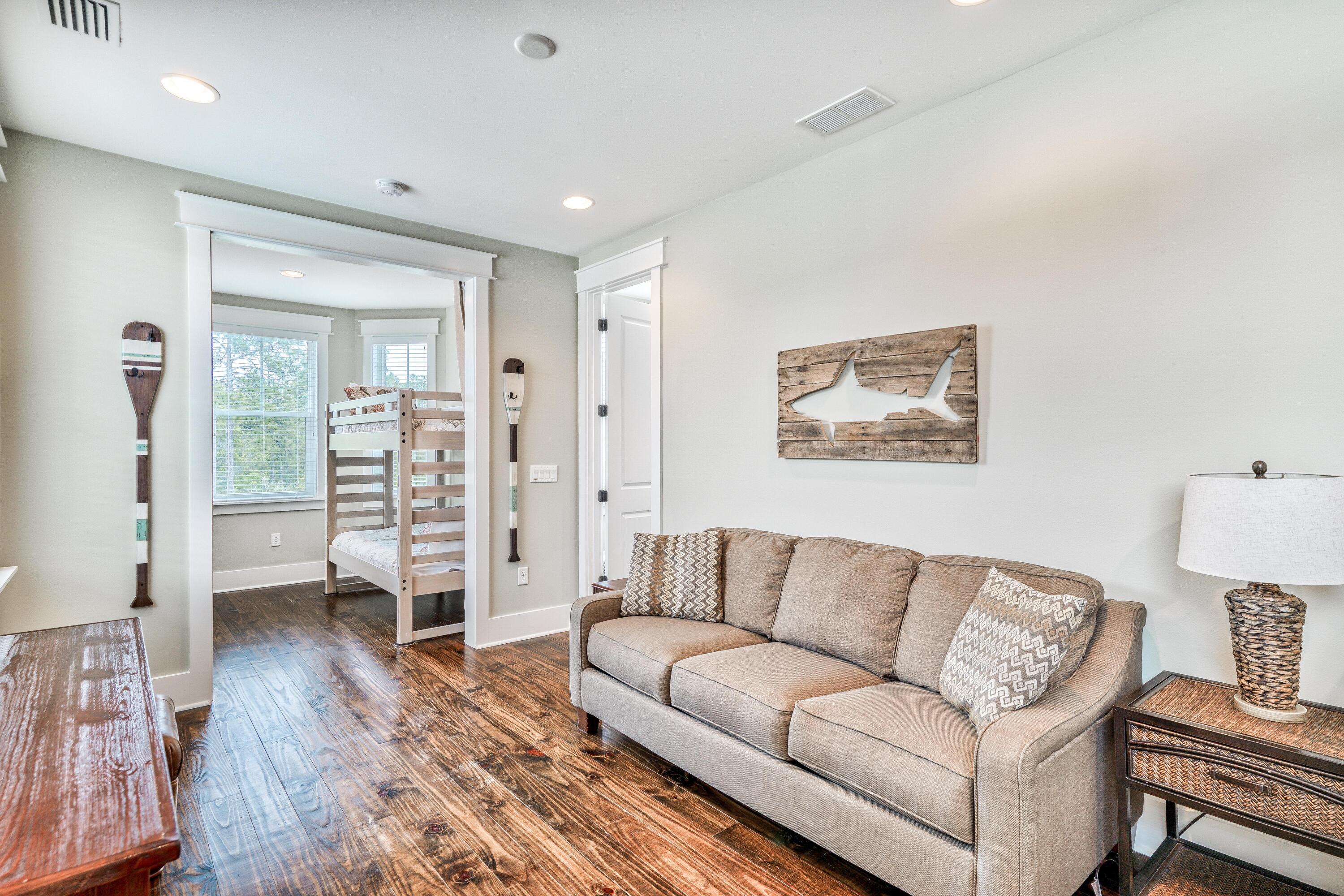 985 Sandgrass Boulevard Santa Rosa Beach, FL 32459 - Photo 26 of 65 a living room with furniture and a wooden floor