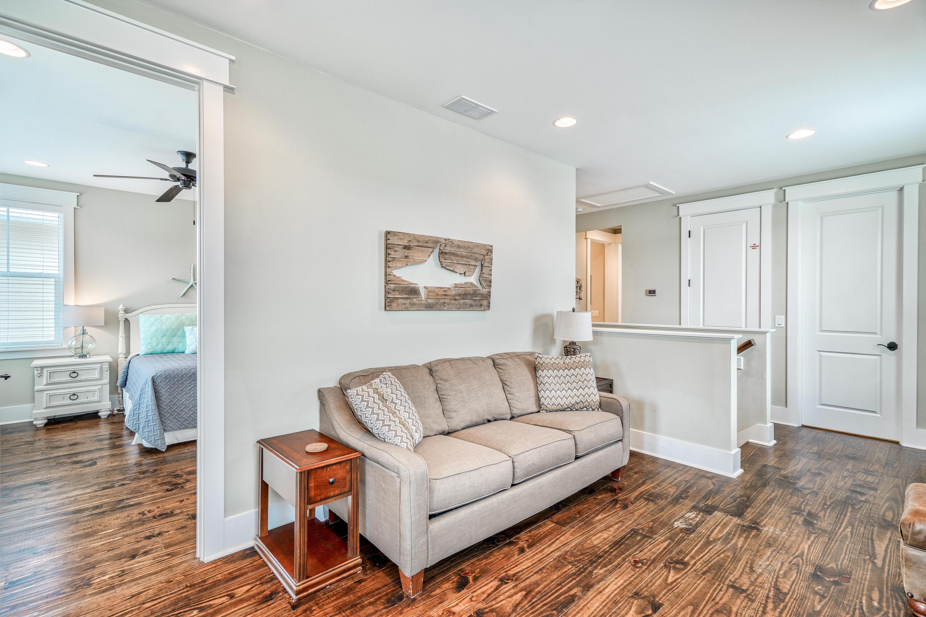 985 Sandgrass Boulevard Santa Rosa Beach, FL 32459 - Photo 27 of 65 a living room with furniture and a wooden floor