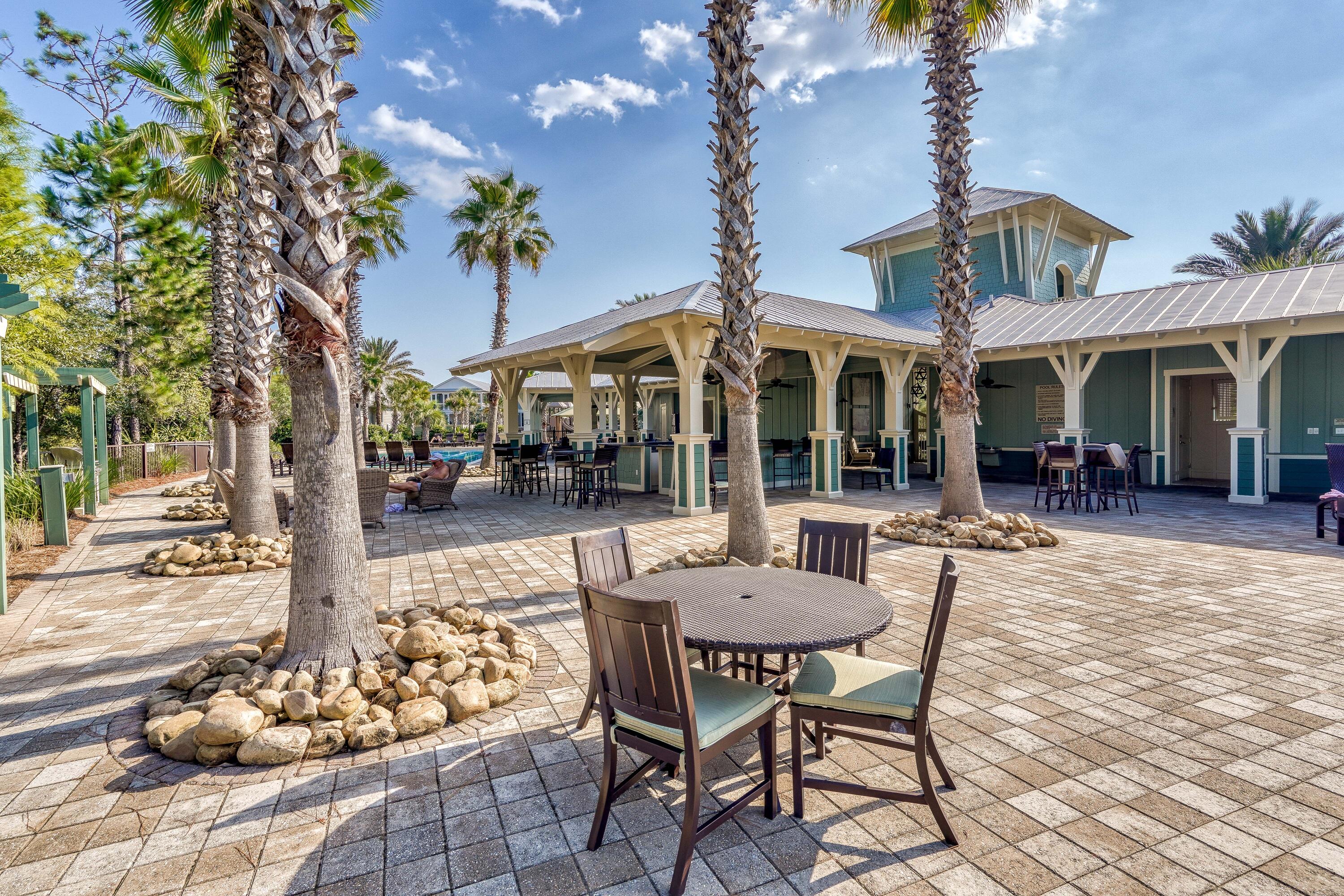 985 Sandgrass Boulevard Santa Rosa Beach, FL 32459 - Photo 50 of 65 a view of a patio with a table and chairs and floor to ceiling window