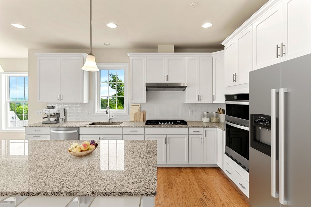 57 Sienna Circle, Unit 44 Upton, MA 01568 - Photo 4 of 21 a kitchen with kitchen island granite countertop a stove a sink and a refrigerator