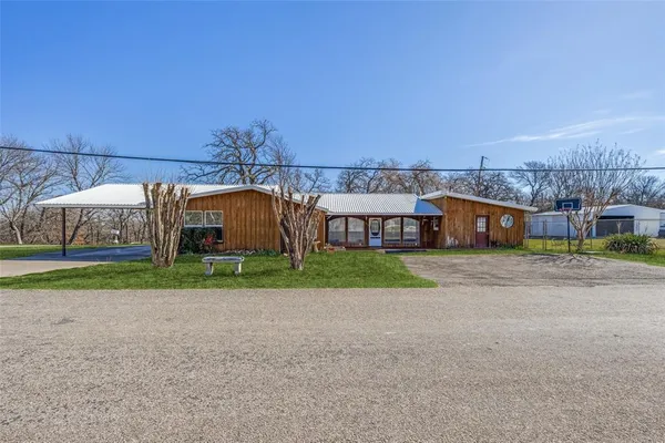 a view of a big house with a big yard and large trees