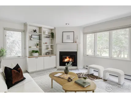 a living room with painting on the wall and a fireplace