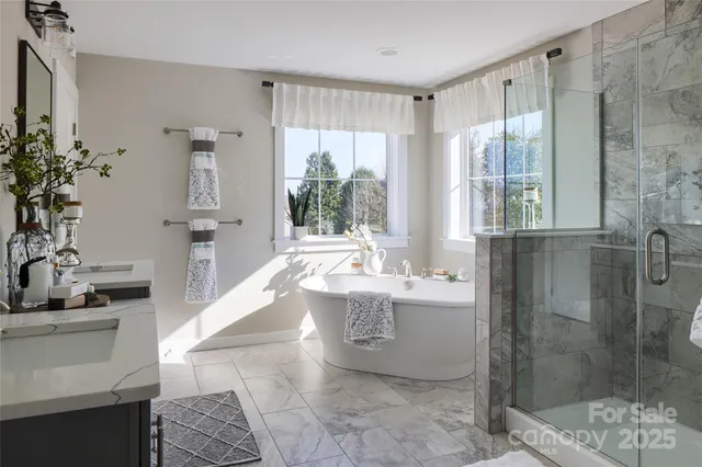 a spacious bathroom with a tub sink and mirror