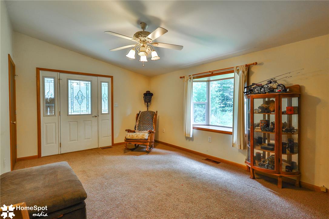 3795 Rhoades Road Kempton, PA 19529 - Photo 25 of 42 A welcoming living area featuring a decorative entry door with sidelights, complemented by a broad window overlooking a verdant outdoor space.