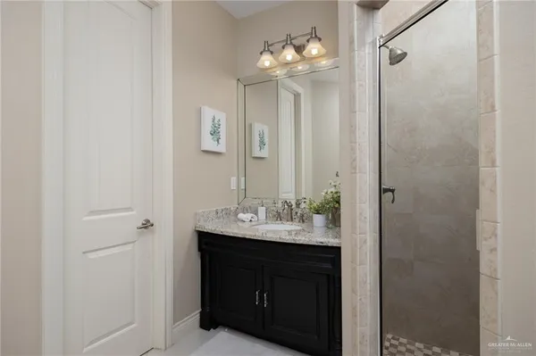 a bathroom with a sink shower and a mirror