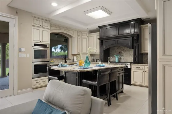 a kitchen with kitchen island granite countertop a sink cabinets and stainless steel appliances