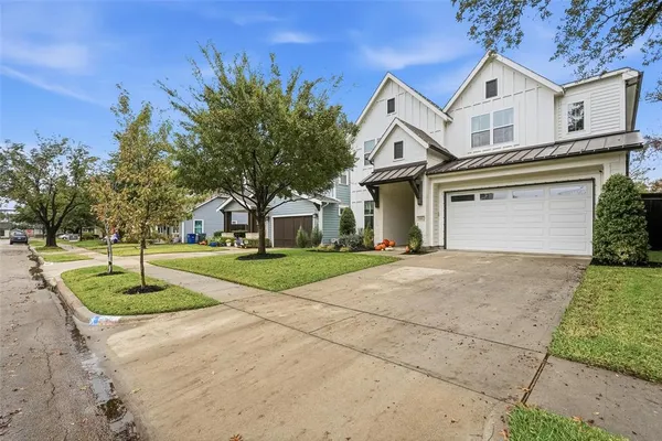 a front view of a house with a yard and trees