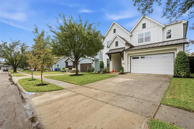 a front view of a house with a yard and trees