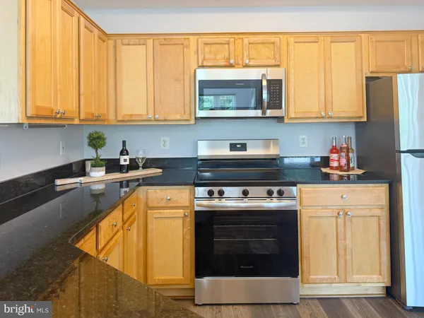 a kitchen with stainless steel appliances granite countertop a stove microwave and cabinets